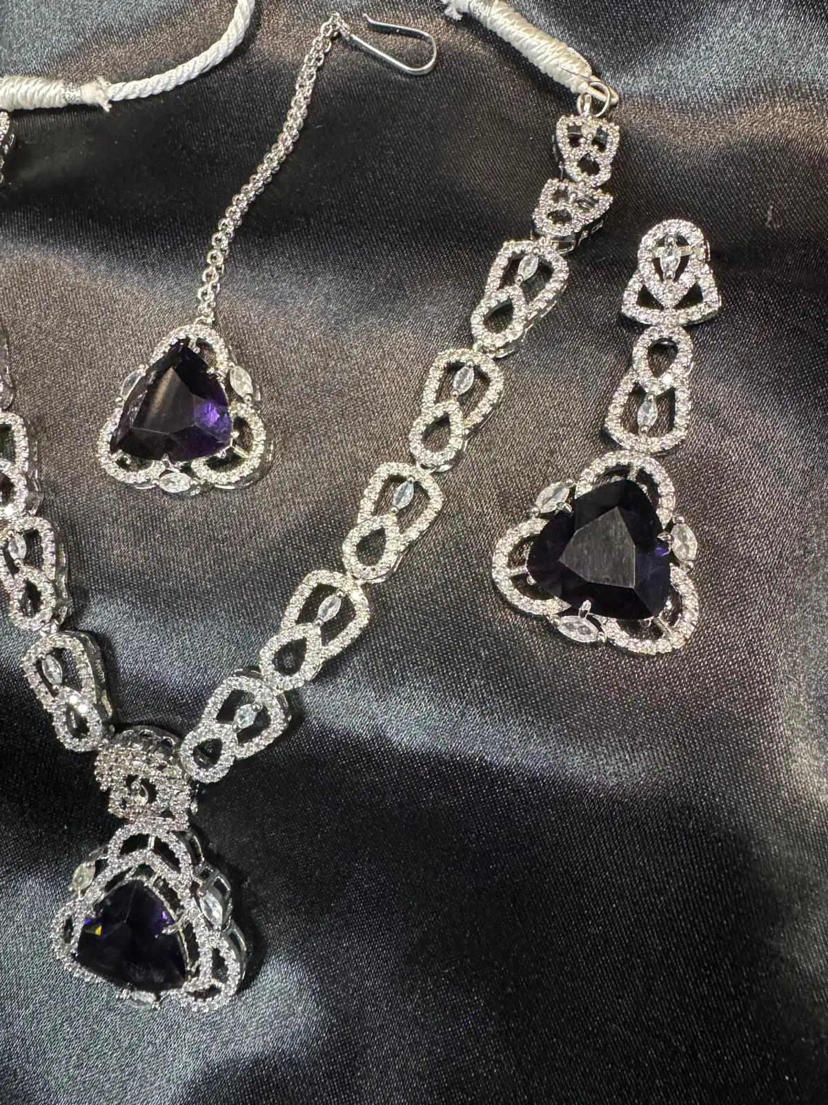 Close-up of JV158 necklace pendant featuring a violet heart-shaped CZ stone with silver loops and crystals.