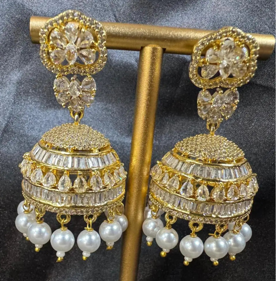 A pair of Pakistani design intricate Jhumka with nano zarcon and jarao craftsmanship. They are gold plated and waterproof having clear stones and pearl like drops.