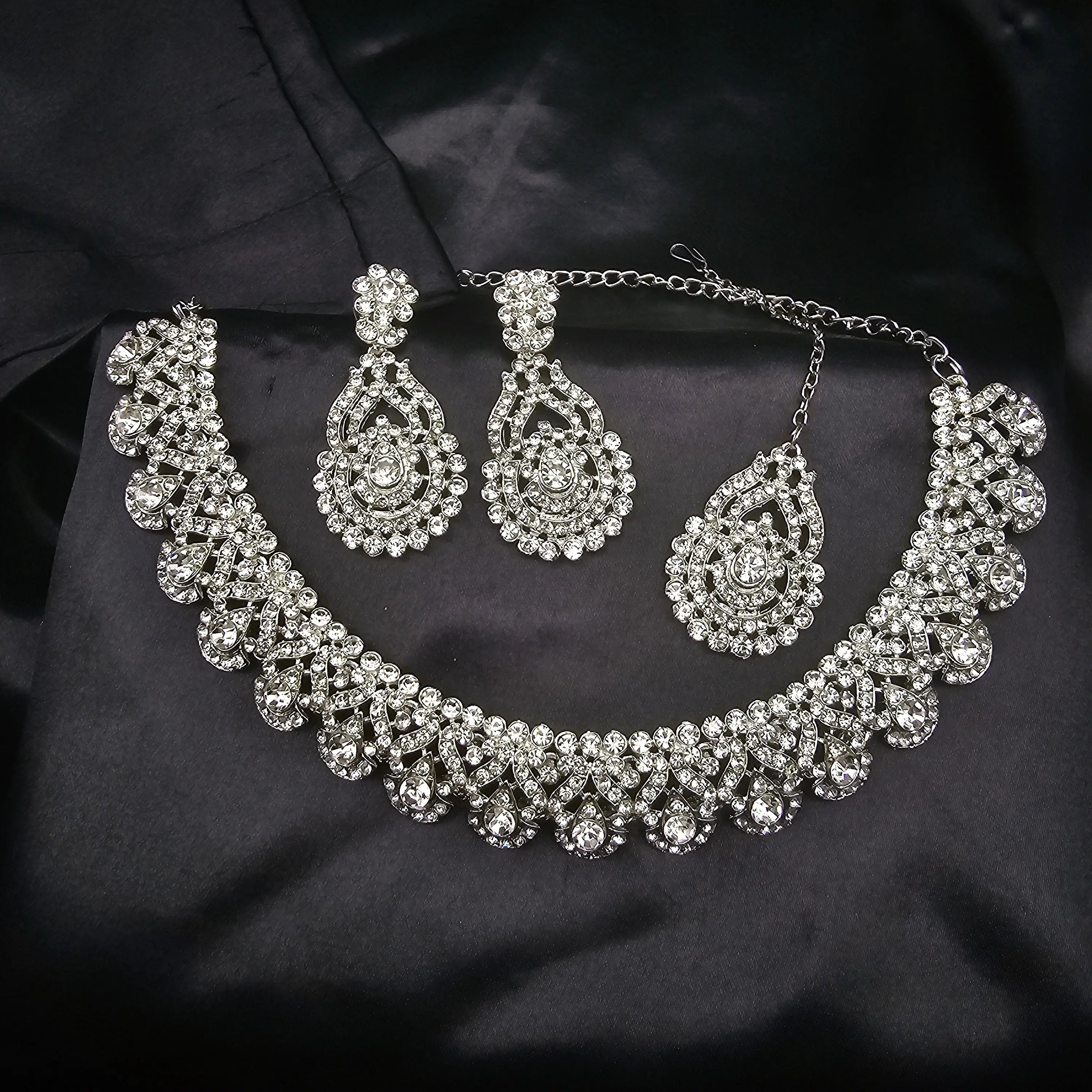 Full view of Lorea statement necklace set with clear zircon gemstones, laid flat on black background