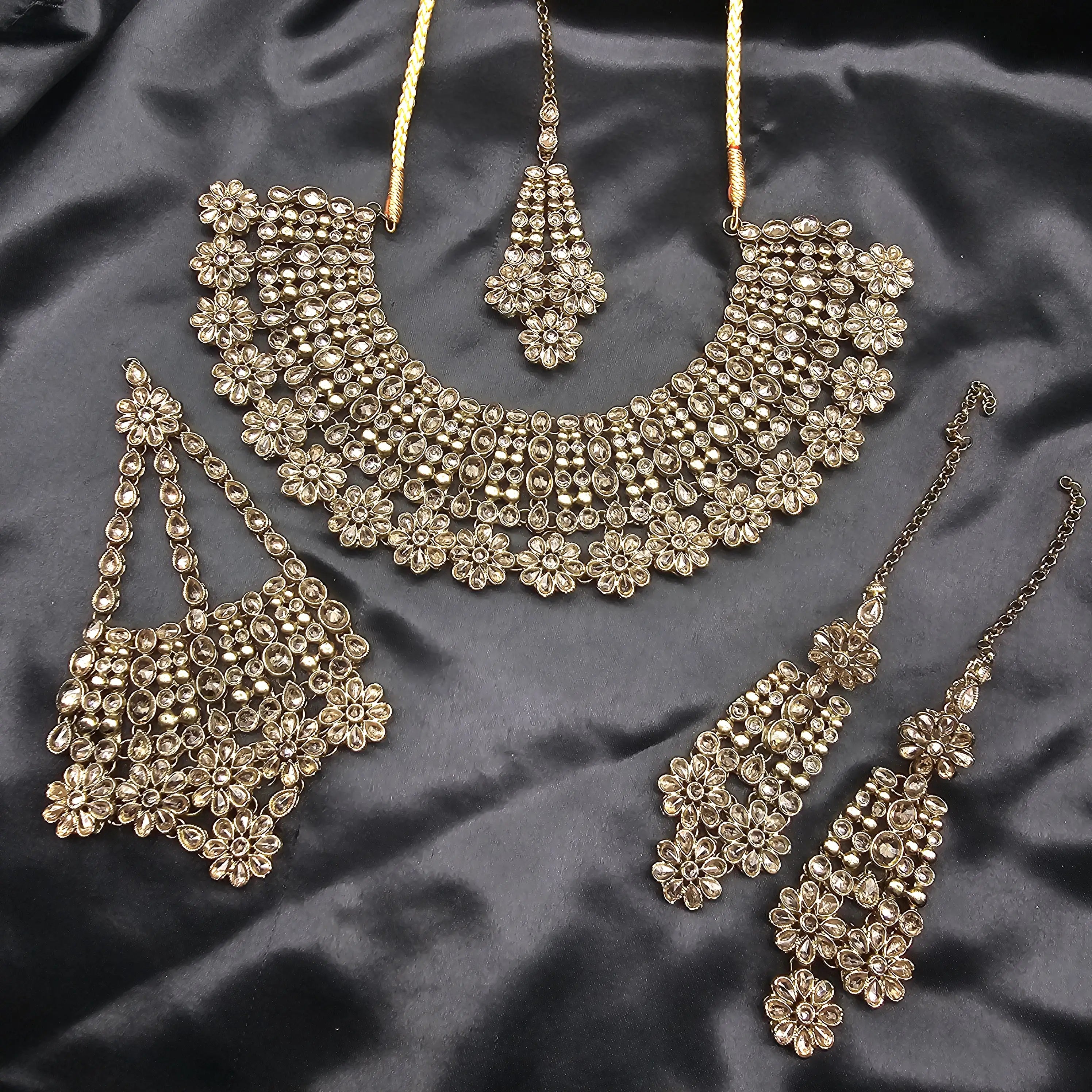 Full layout of Magnolia jewelry set displayed on dark satin fabric.