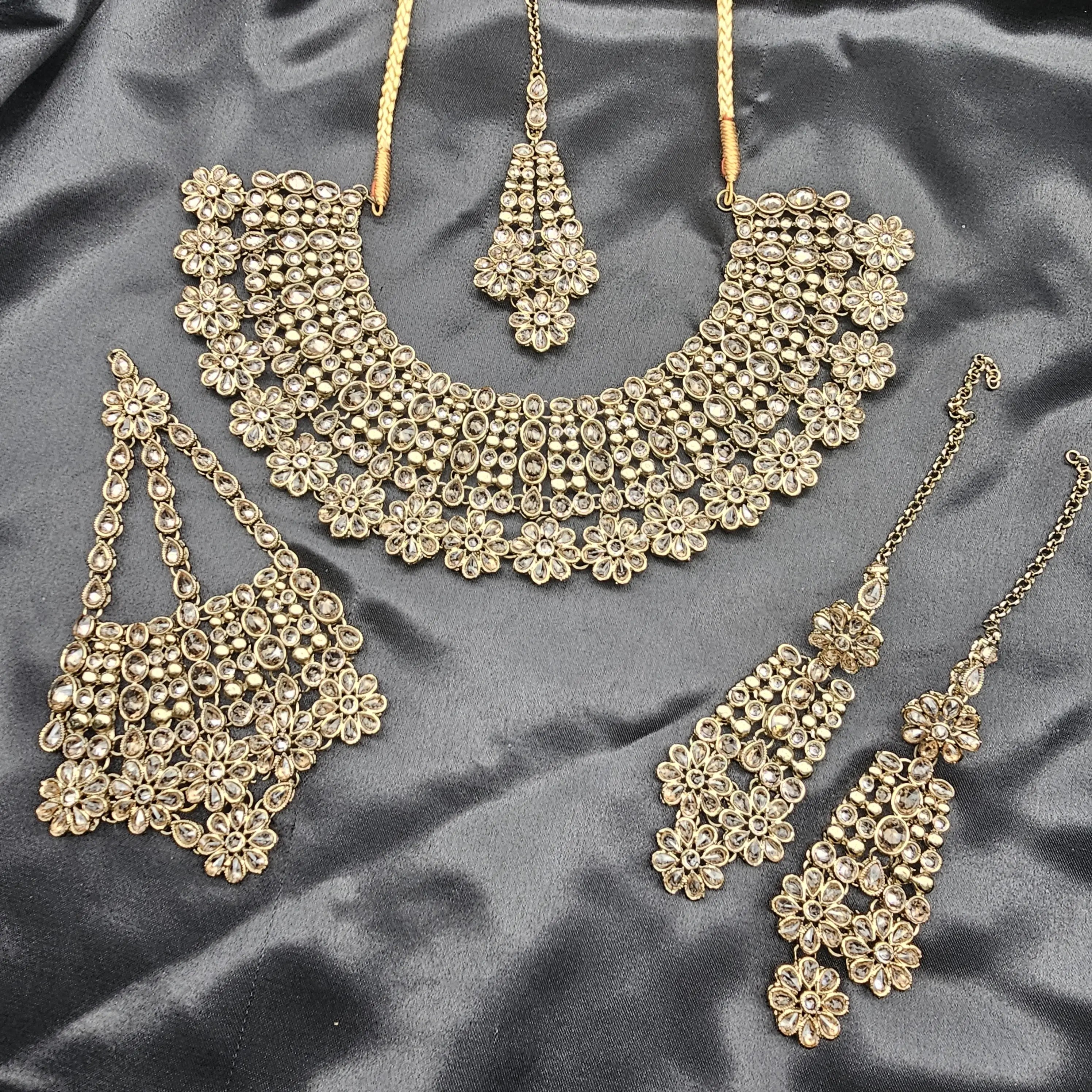 Overhead view showing all components of Magnolia set – choker, earrings, jhoomer, and teeka with intricate stonework.