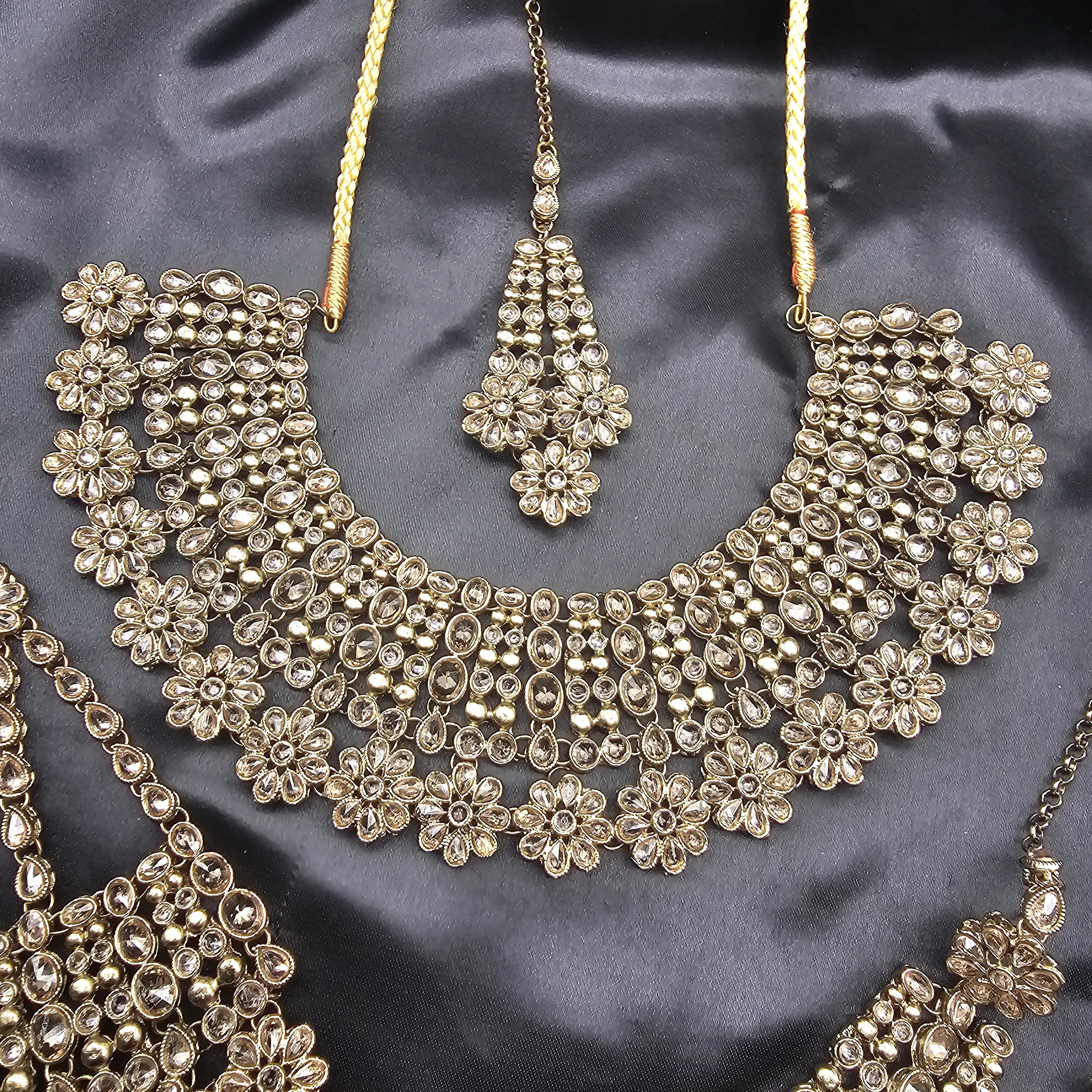 Complete Magnolia bridal jewelry set featuring necklace, teeka, earrings, and jhoomer in floral Kundan design.