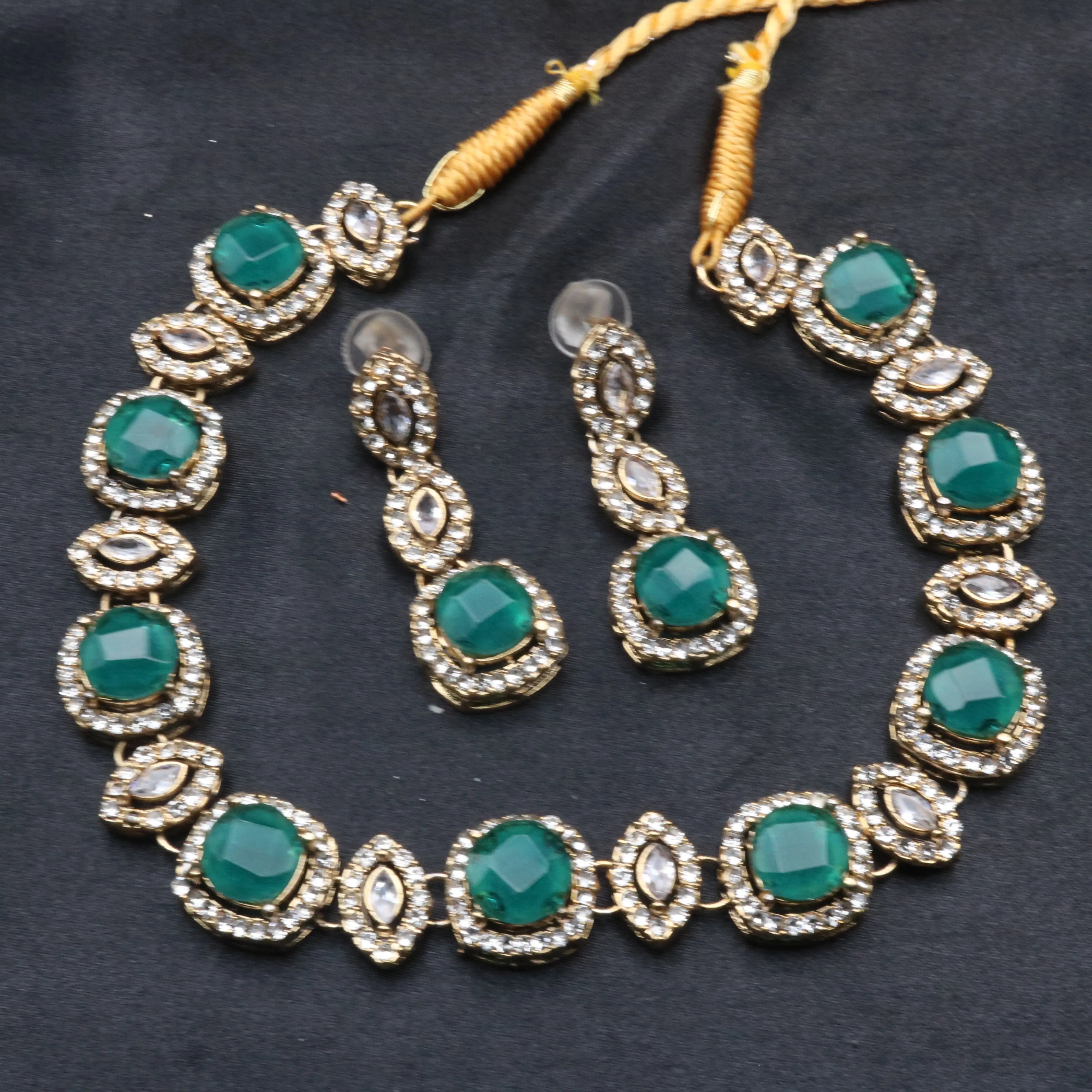 Full emerald variant of Maharani necklace and earrings displayed on black background