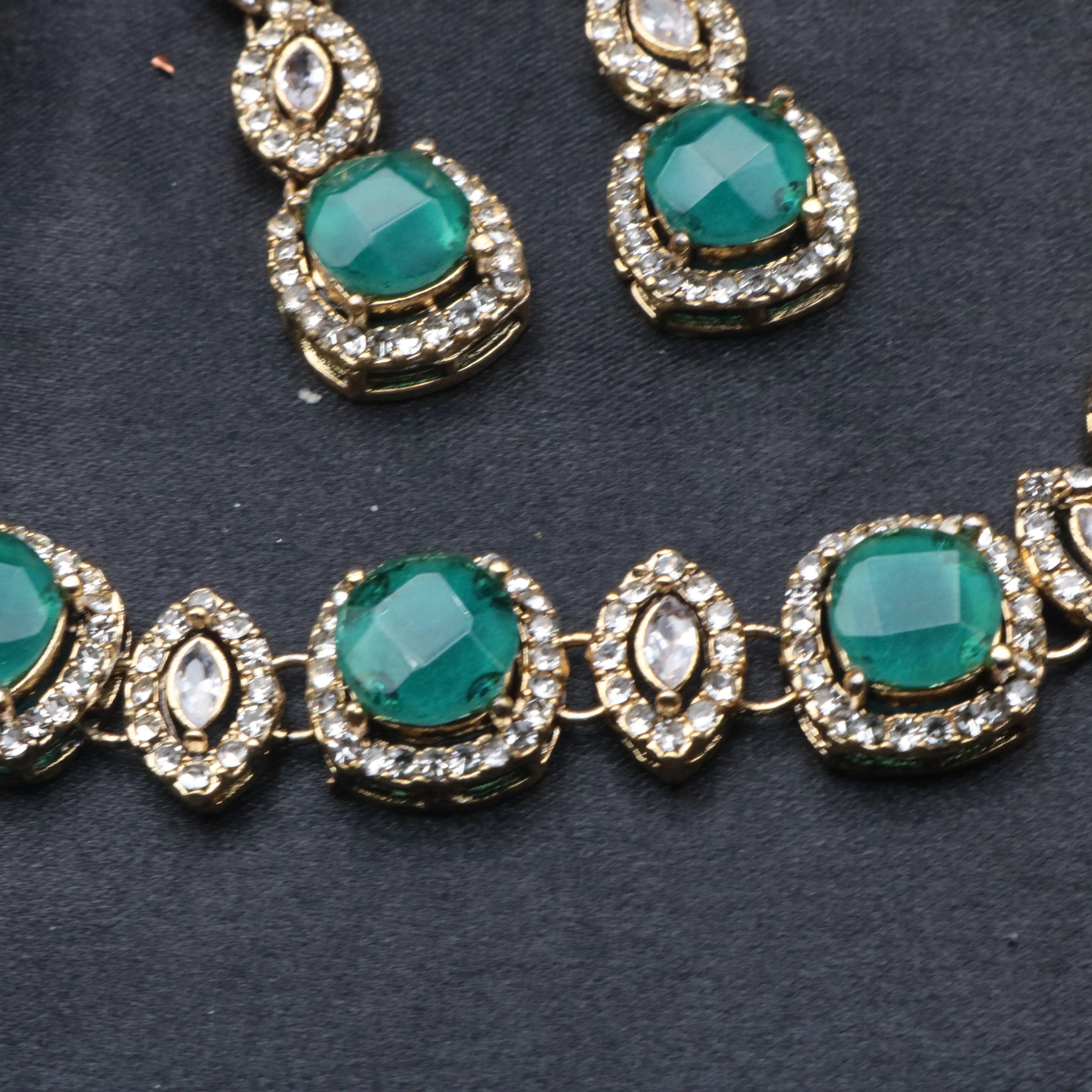 Close-up of emerald green Maharani necklace with round-cut CZ stones and marquise accents