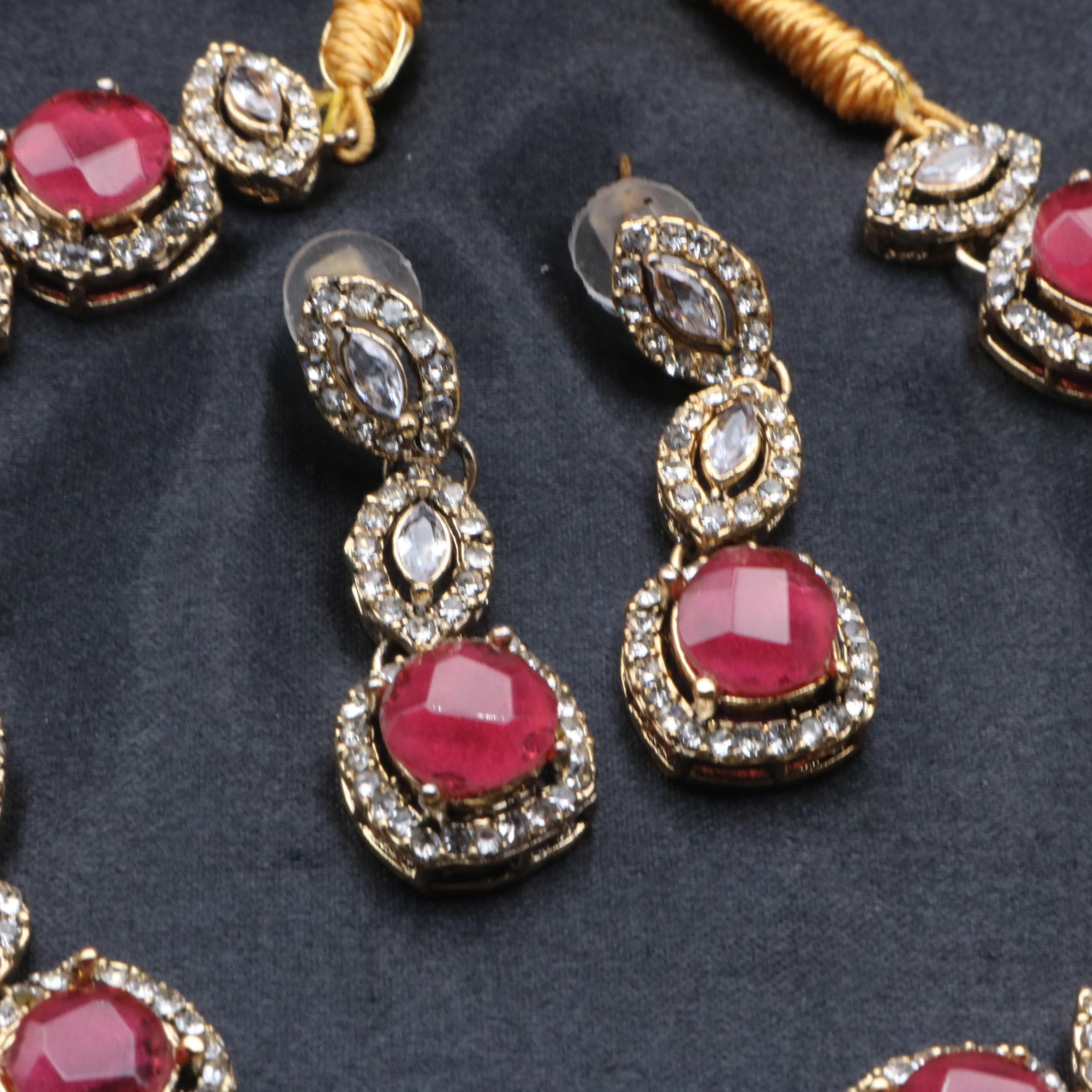 Close-up of ruby Maharani earrings with marquise CZ stones and American diamond halo