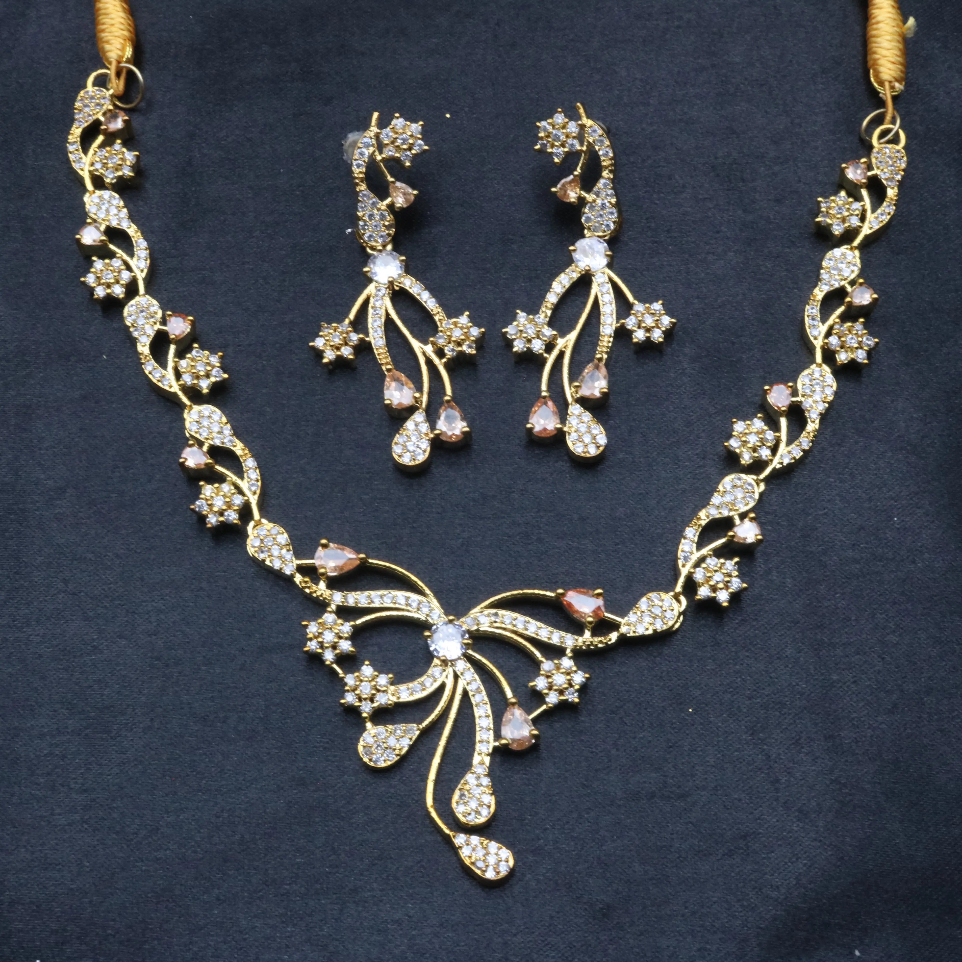 Opera gold-plated necklace set with floral CZ design and matching earrings laid on dark background