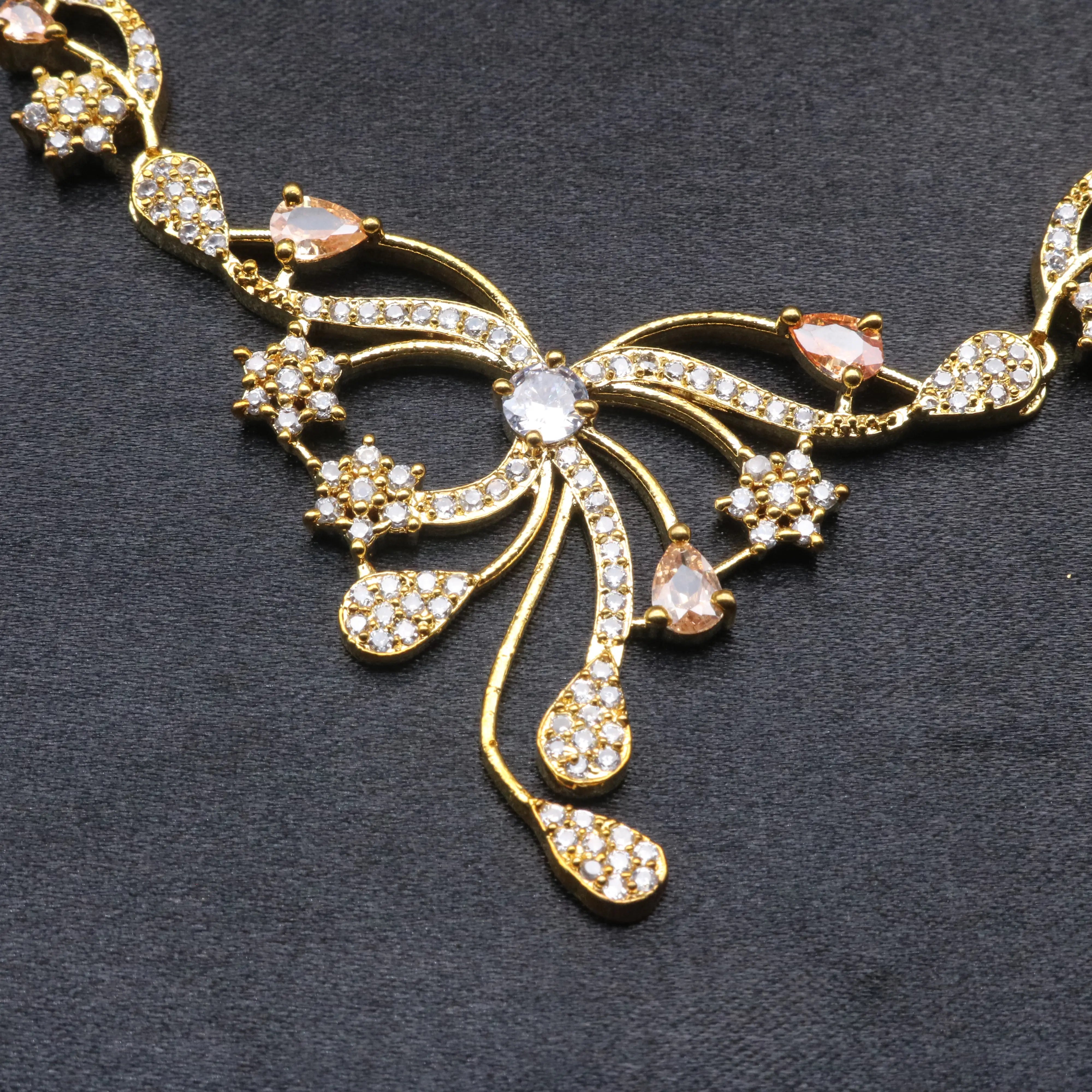 Detailed view of Opera necklace centerpiece with gold-plated strands, floral star motifs, and CZ teardrops