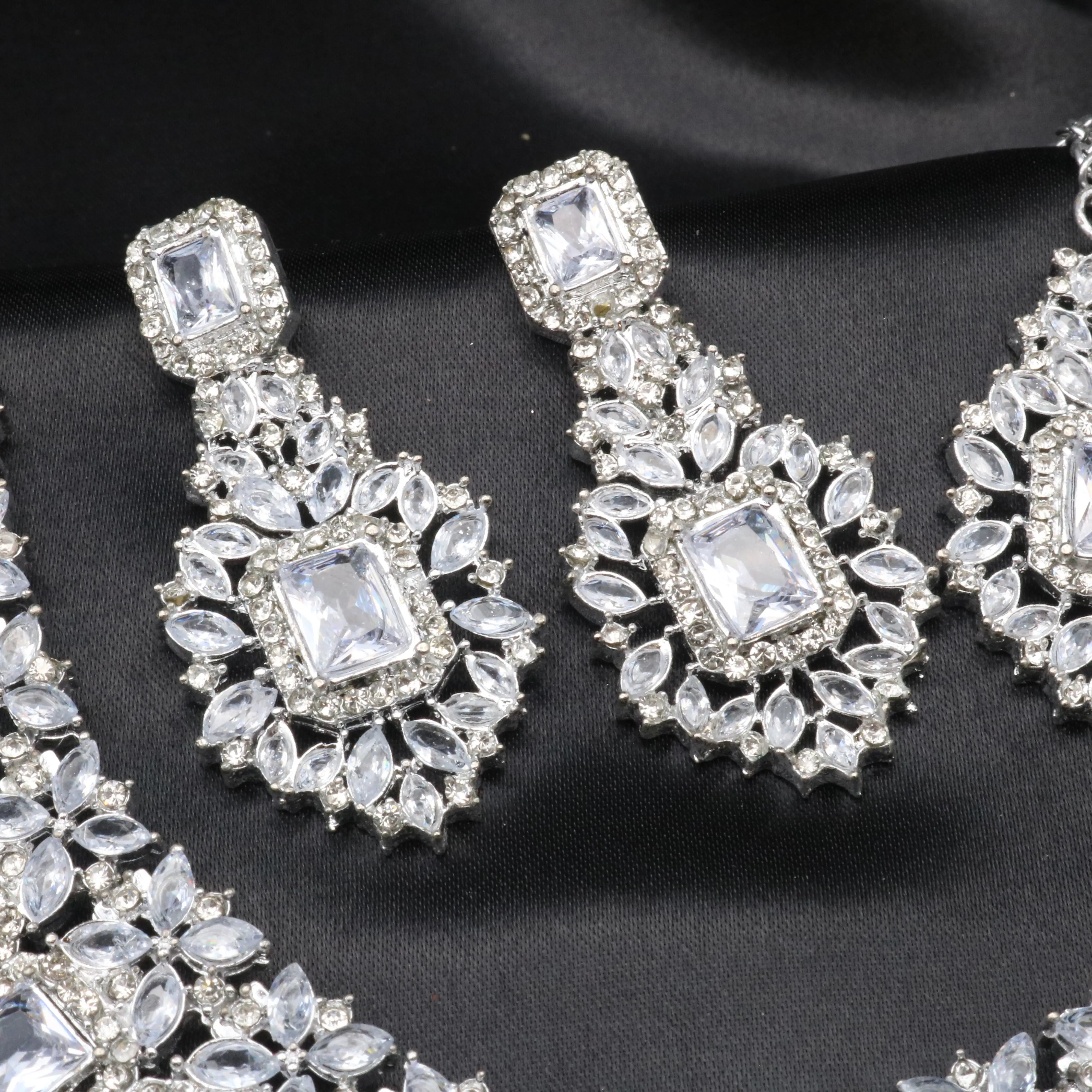Close-up of Pascal white earrings with rectangular CZ center stone and American diamond floral detailing