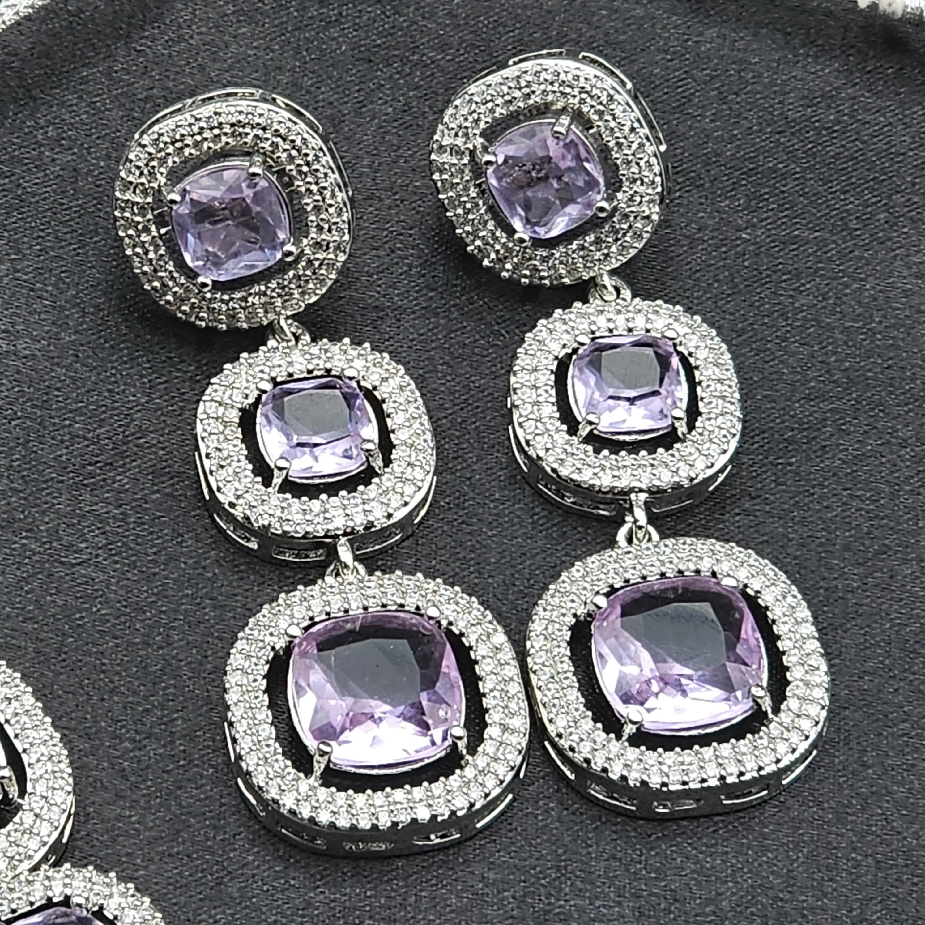 Triple-drop purple earrings with American diamond halos and cushion-cut stones