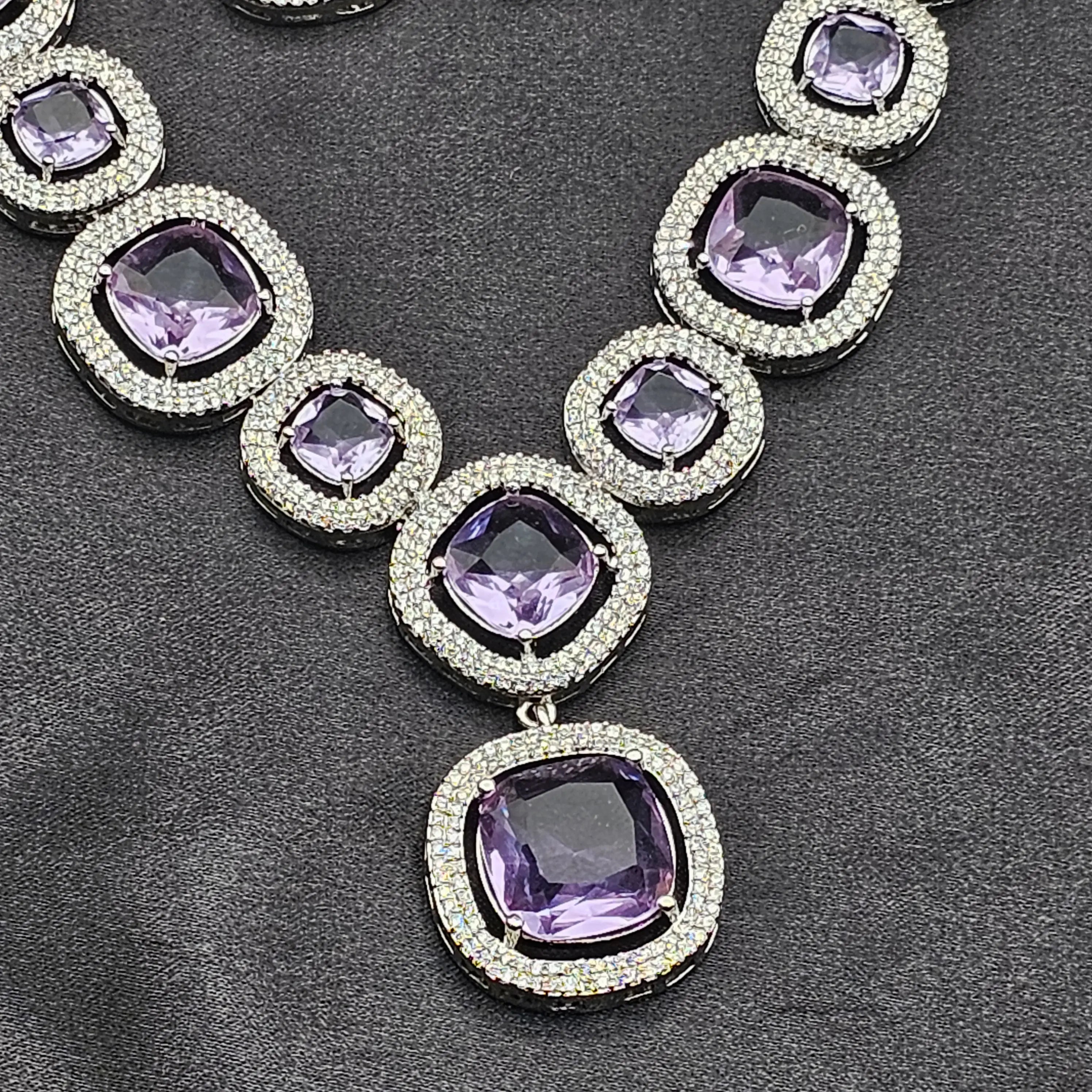 Close-up of Pixie necklace center stone in purple with double CZ border