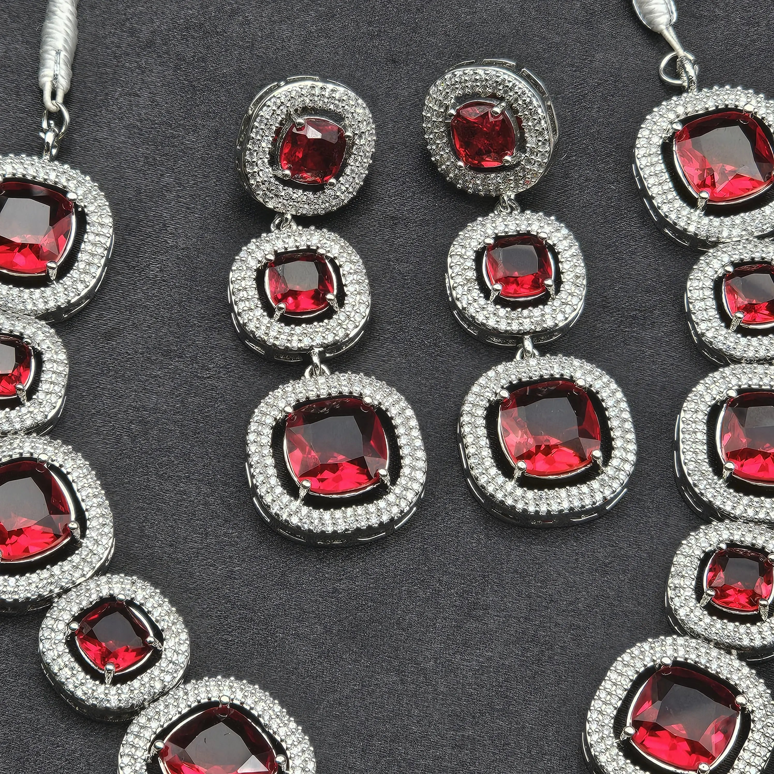 Red cushion-cut stone in center of Pixie necklace, surrounded by American diamonds