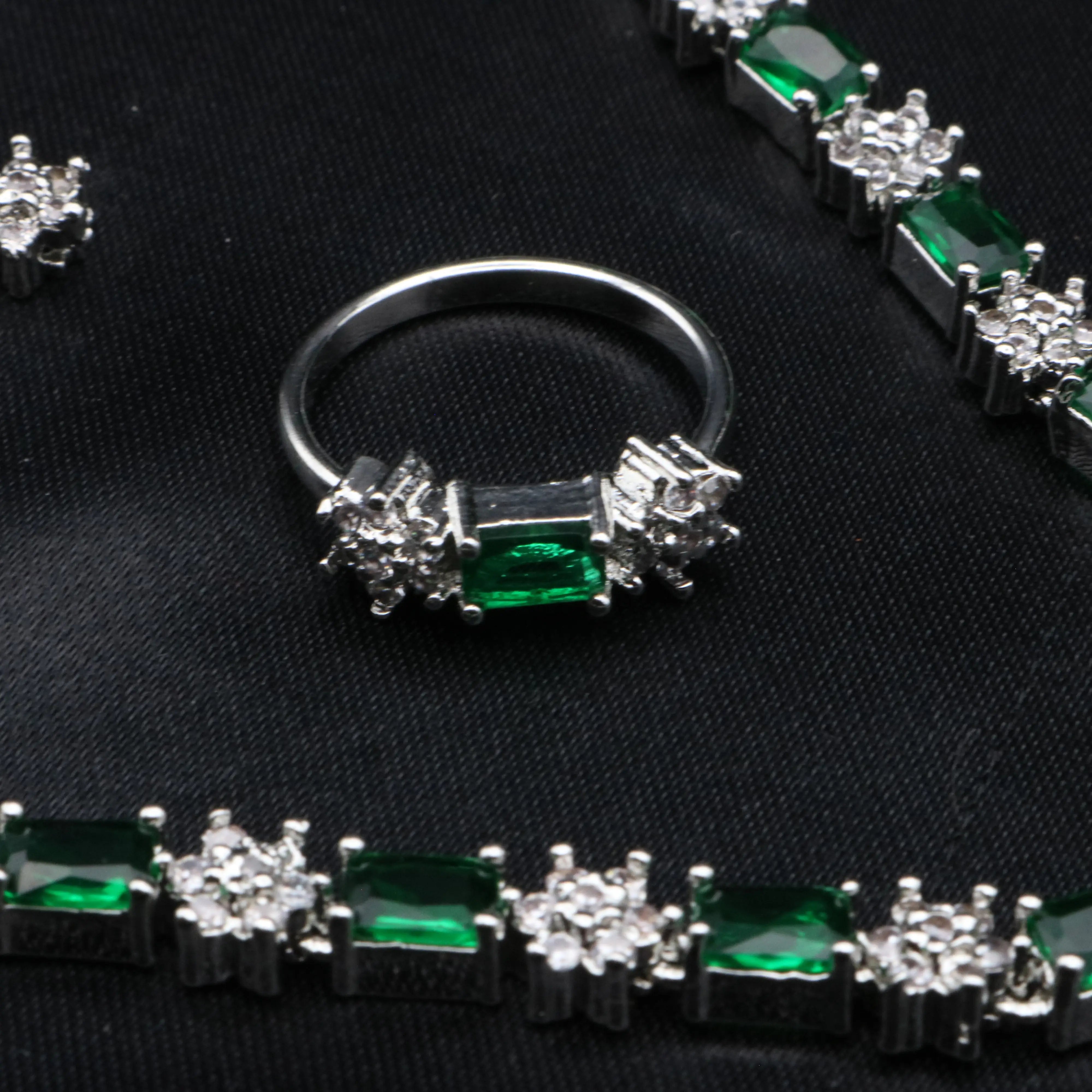 Emerald-cut CZ ring in emerald green with floral American diamond clusters from Reverie set