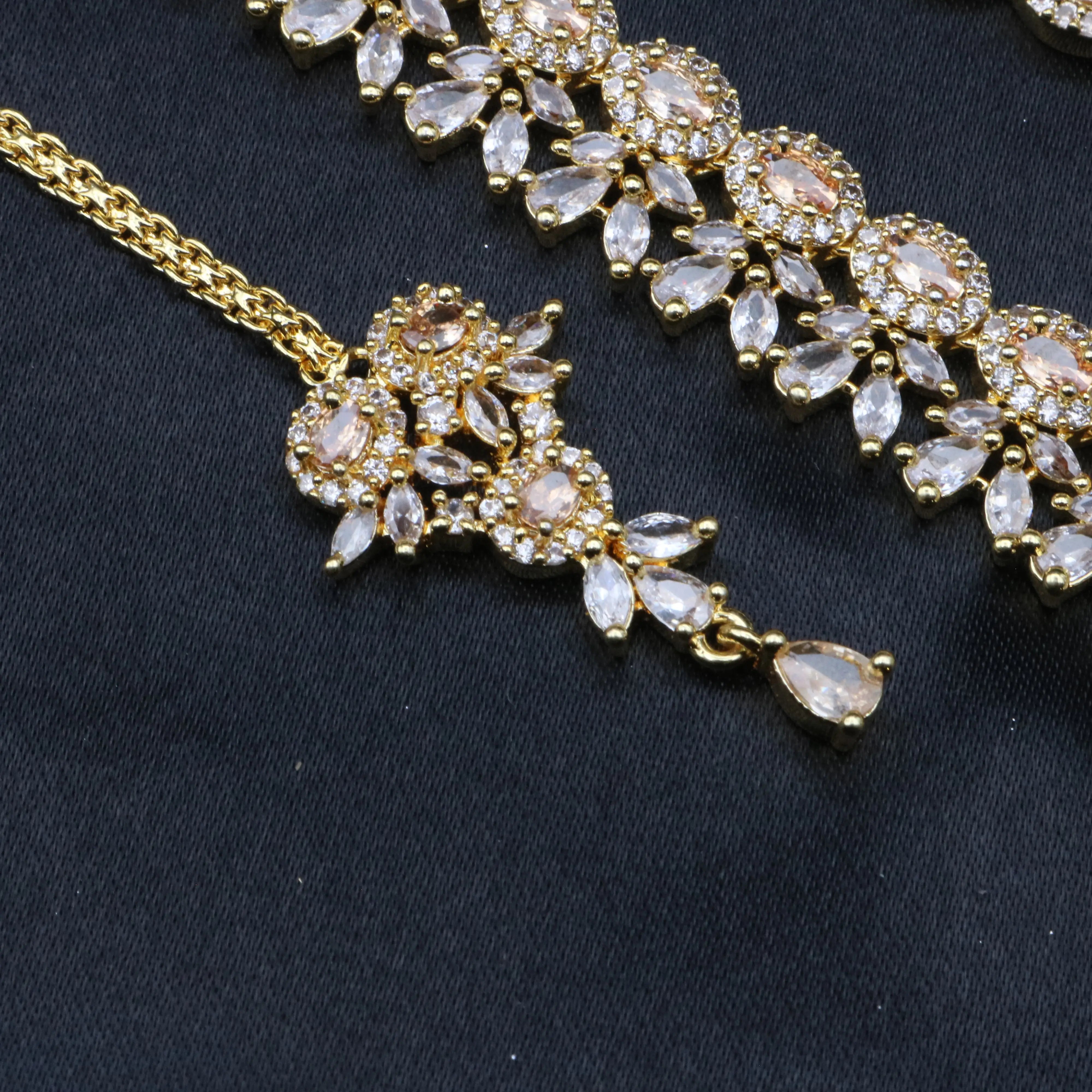 Gold teeka with peach CZ center and American diamond petals from the Royalty necklace set