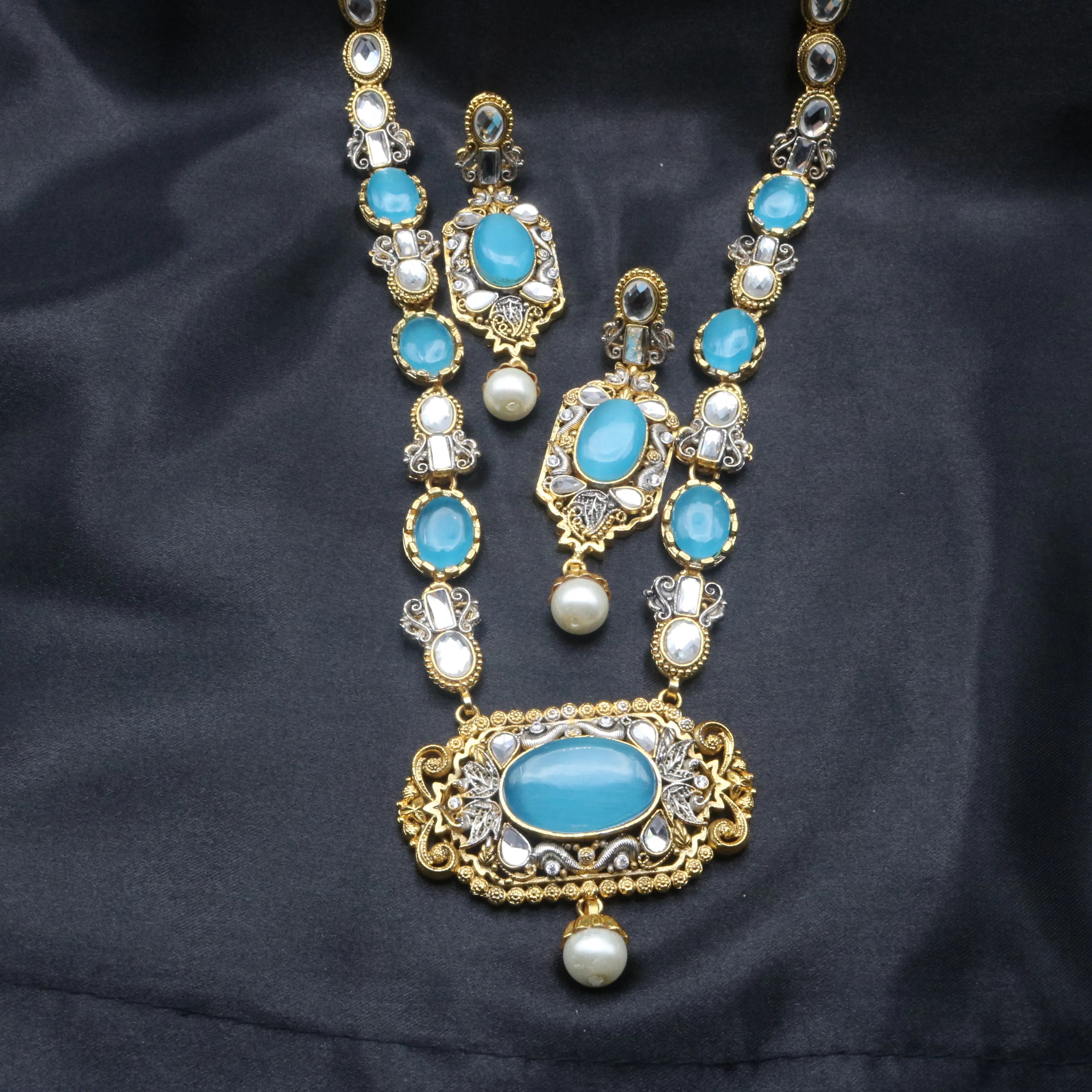 Full Sea Foam necklace set with double strands, matching earrings, and pearl drops laid on black fabric