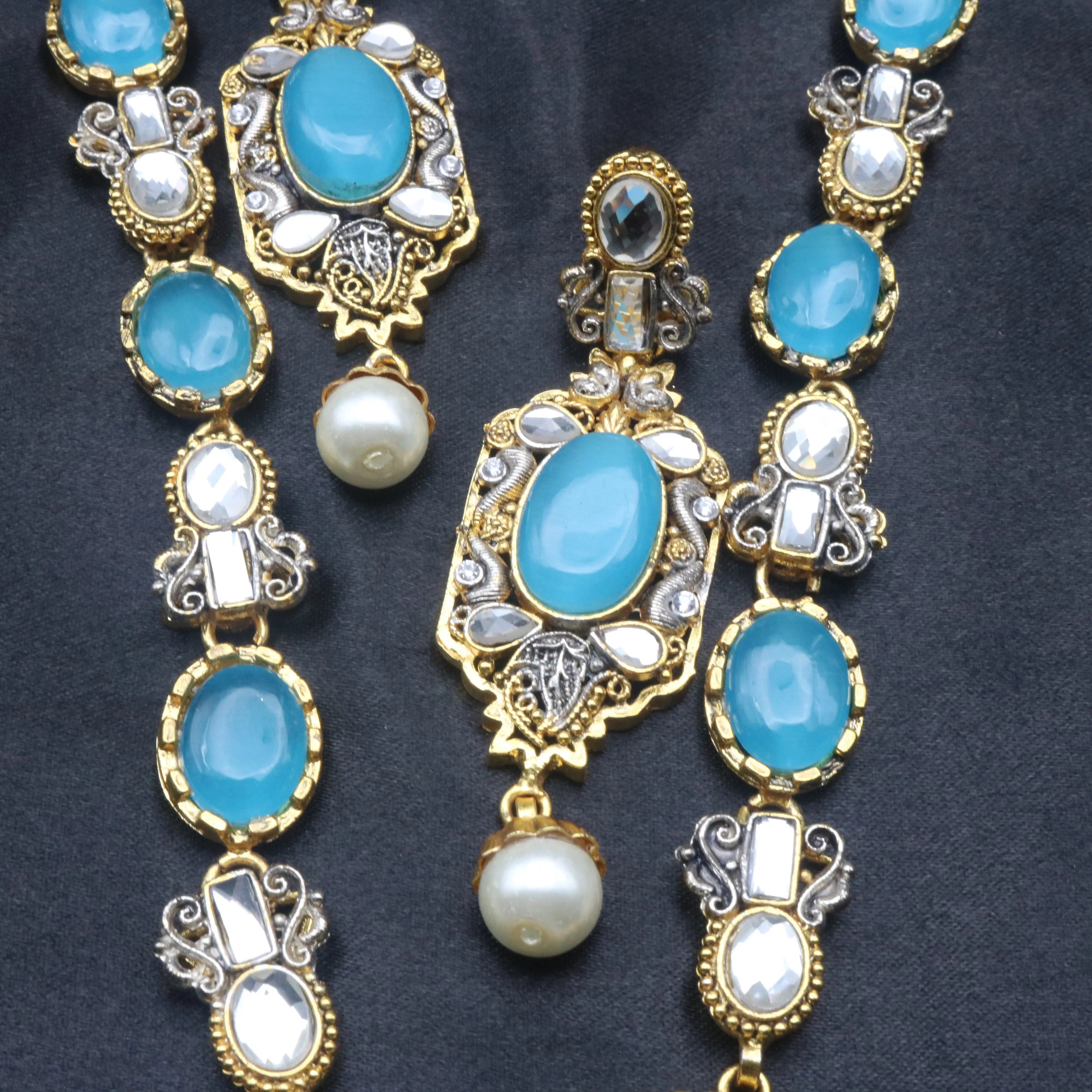 Detailed view of earring and necklace links showing blue stones, kundan mirrors, and ornate metallic design