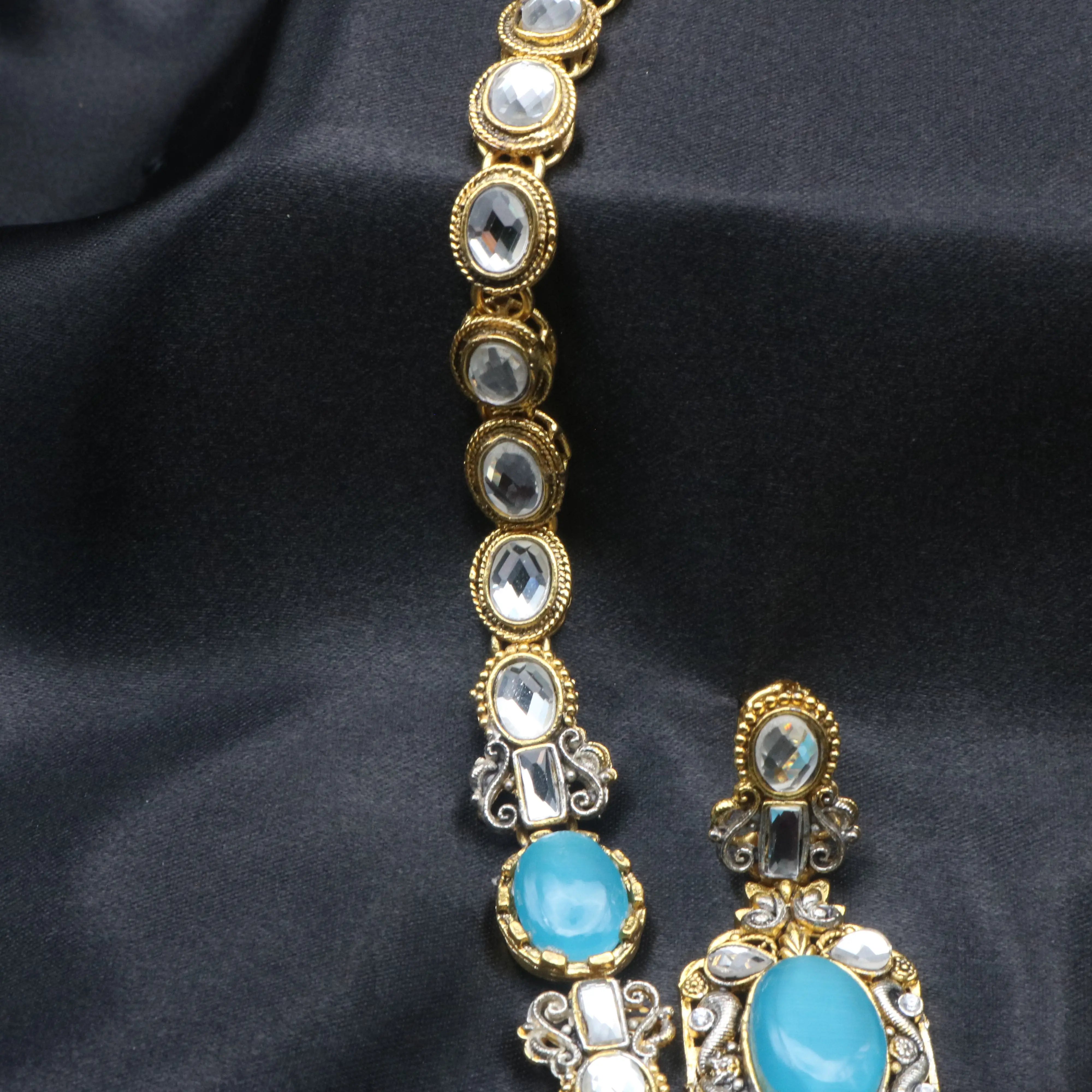 Close-up of Sea Foam necklace detailing aqua blue oval gemstones with kundan-style accents on gold base