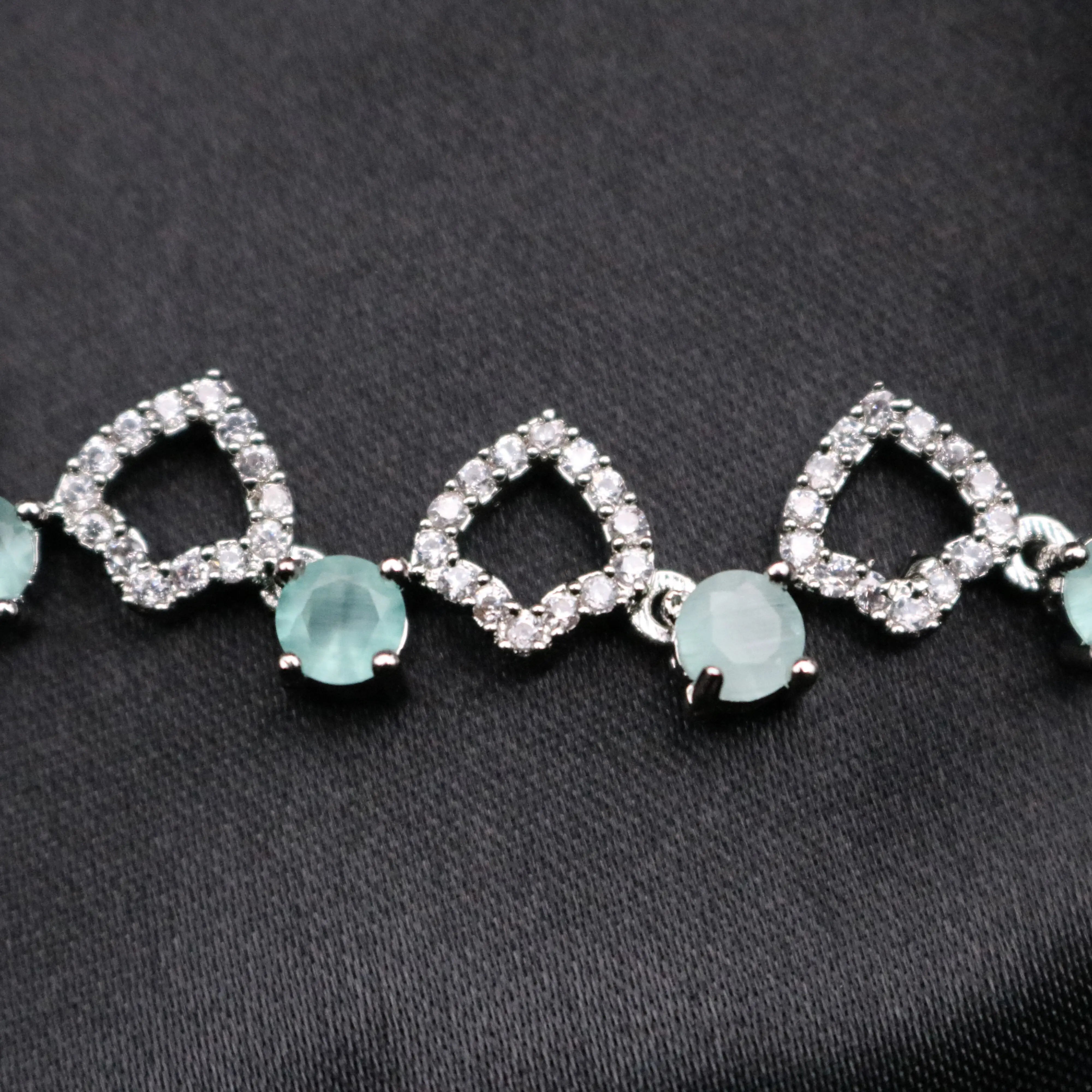 Detailed view of Starlight necklace links with alternating CZ and mint gemstone design