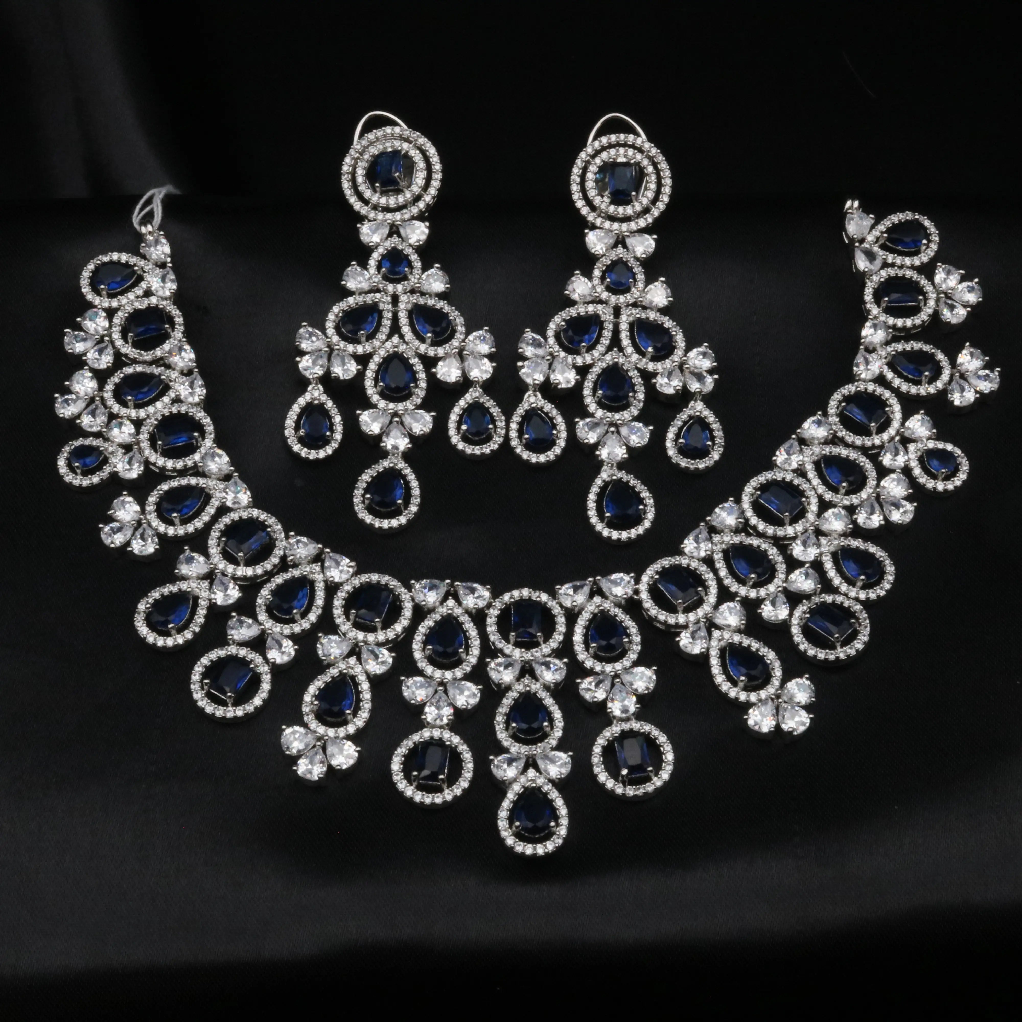 Complete Swanlake necklace and earrings set laid out on a black background