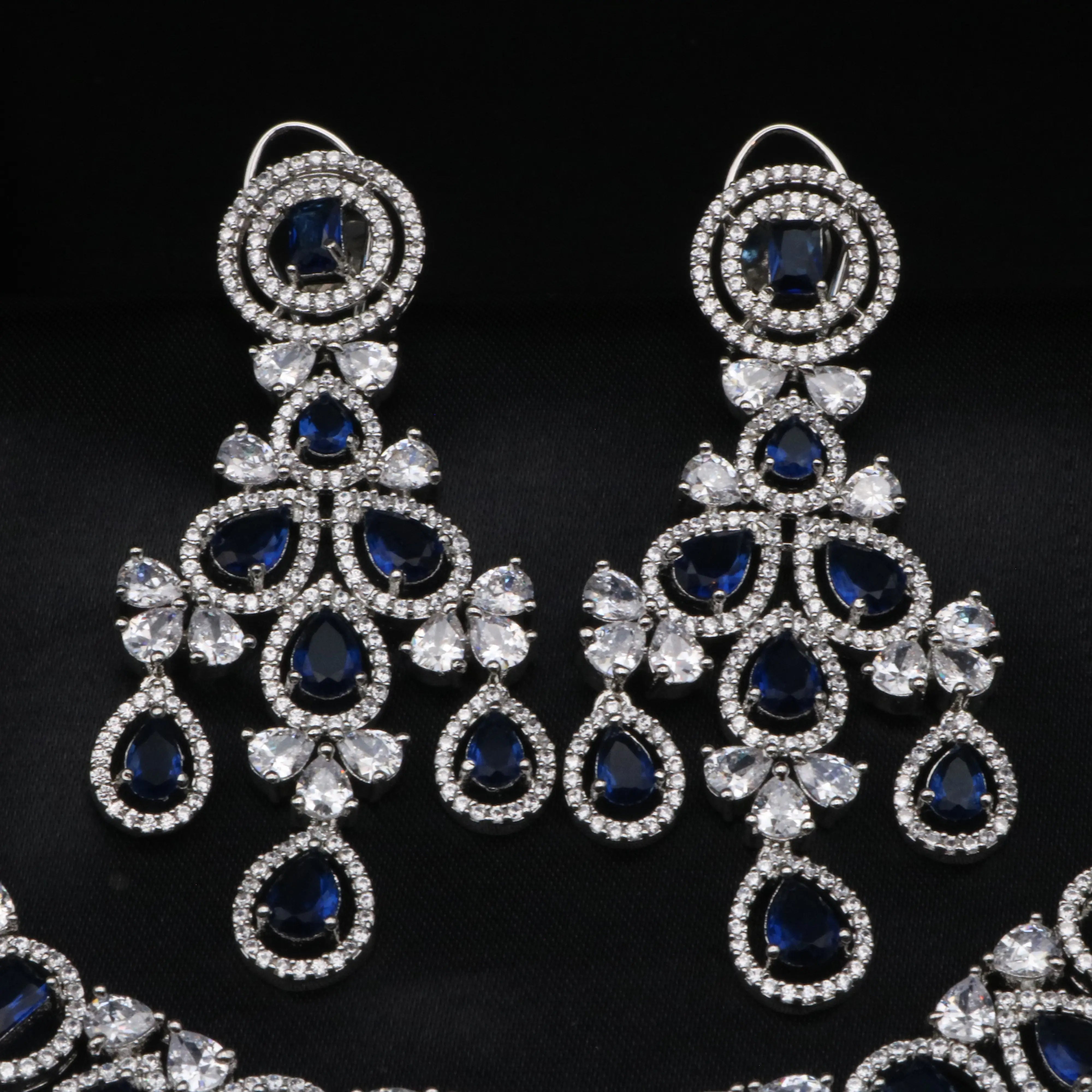 Close-up of Swanlake earrings with royal blue CZ teardrop stones and American diamond halo accents