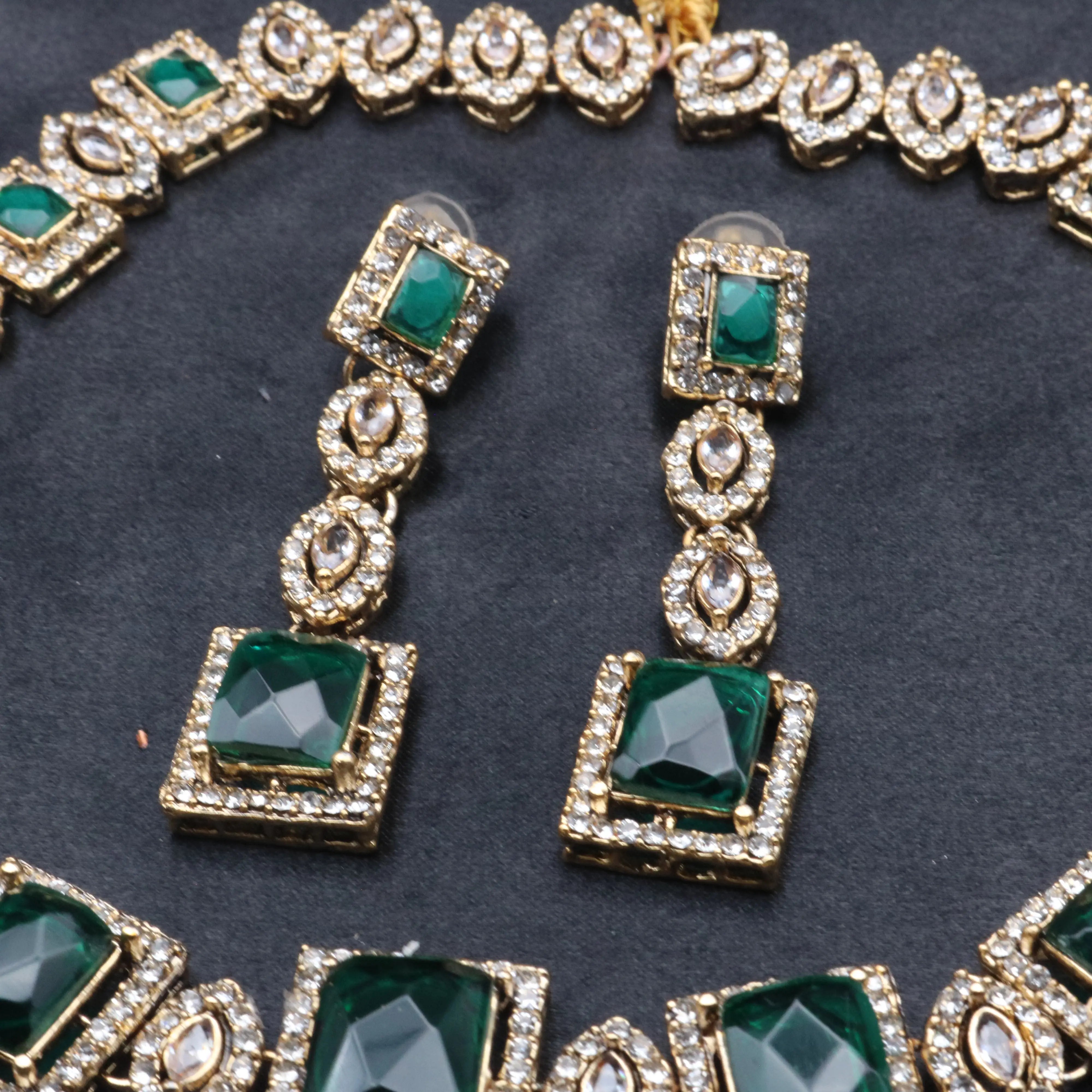Close-up of emerald green earrings from the Taj Mahal necklace set