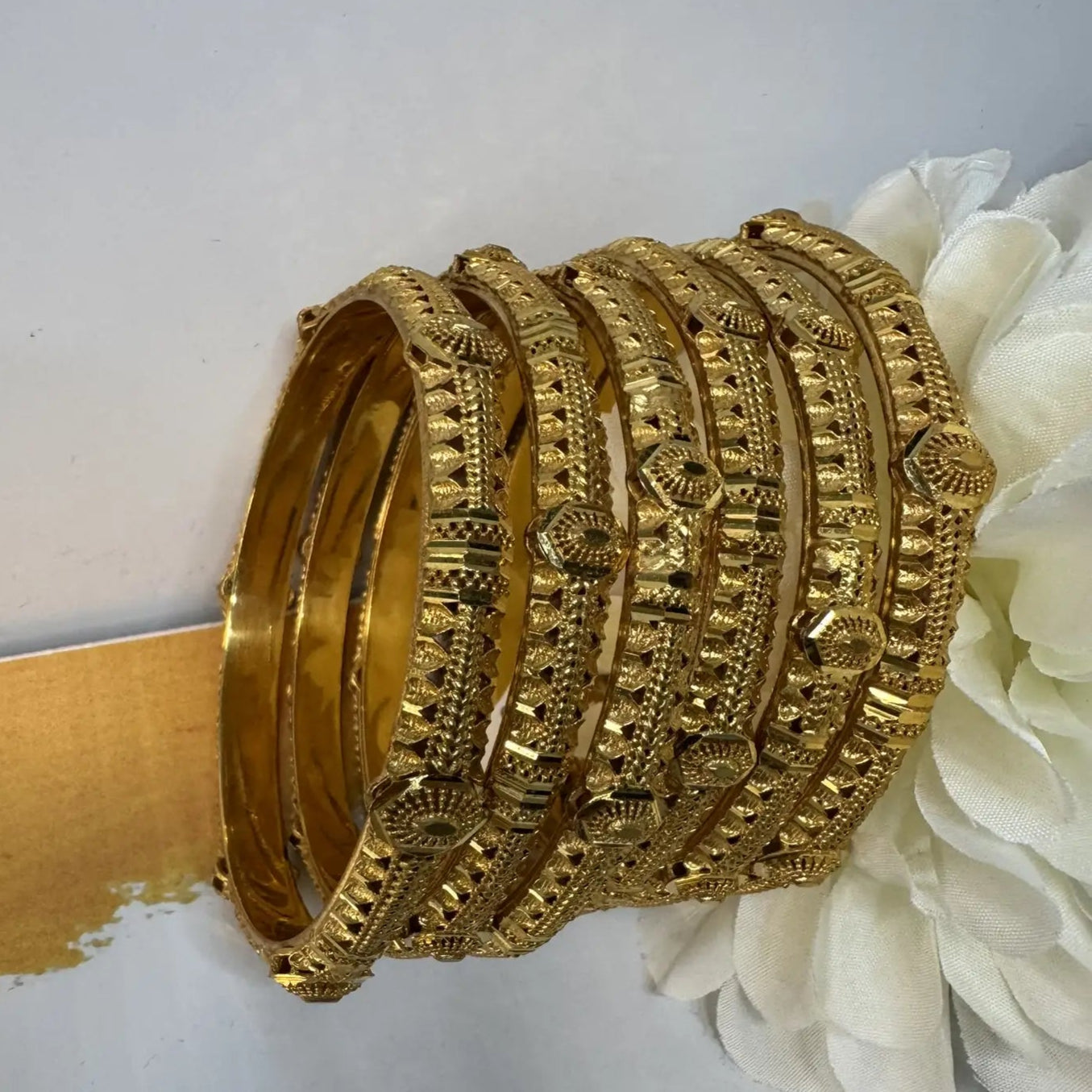 Set of 22k gold plated bangles on a white background