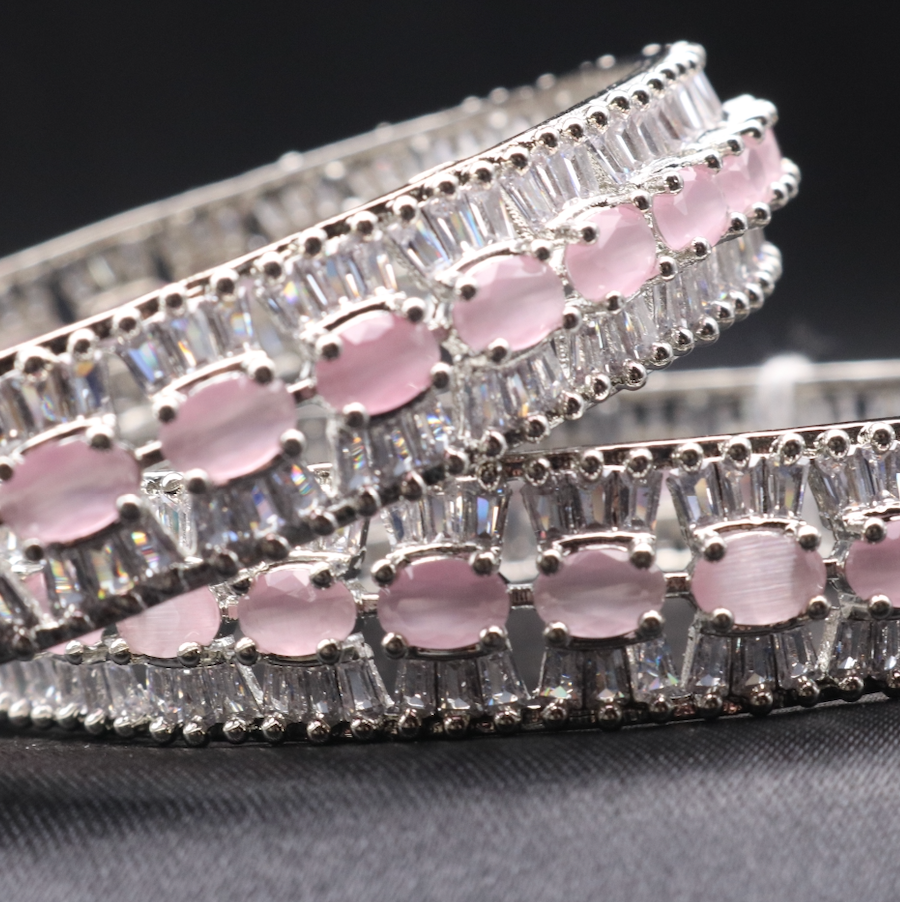 A set of stainless steel bangles adorned with sparkling American diamonds and pink gemstones