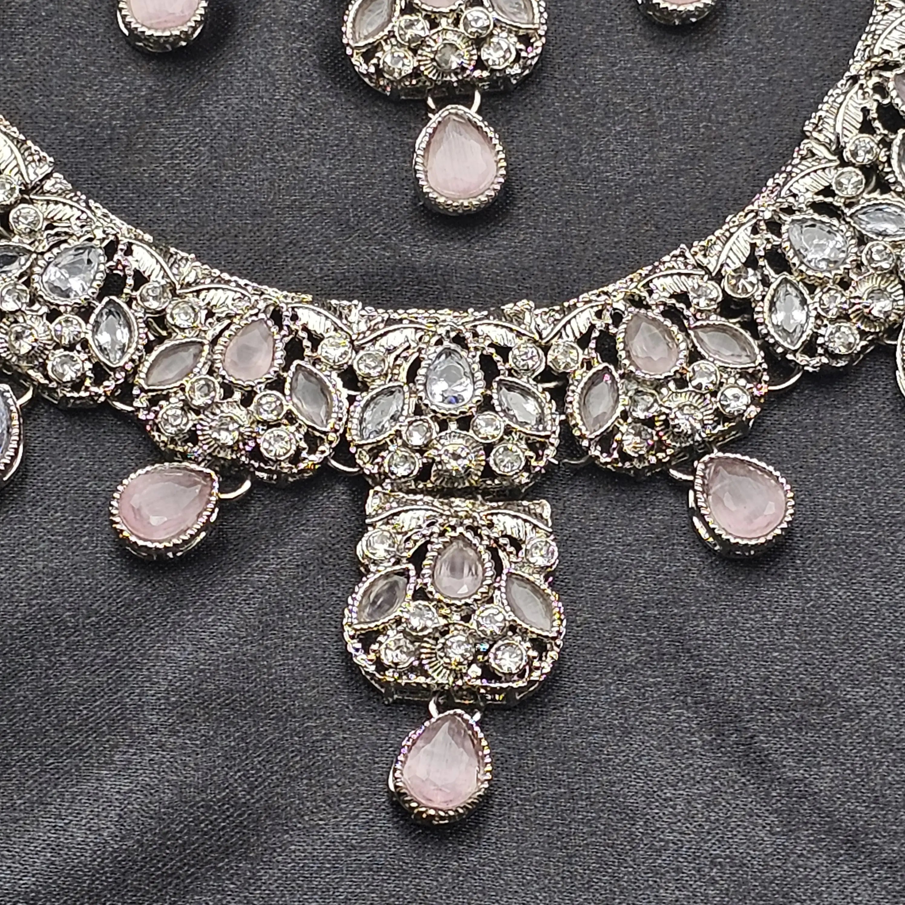 Detailed view of the Zahra necklace featuring pink teardrop stones and silver CZ floral arrangement