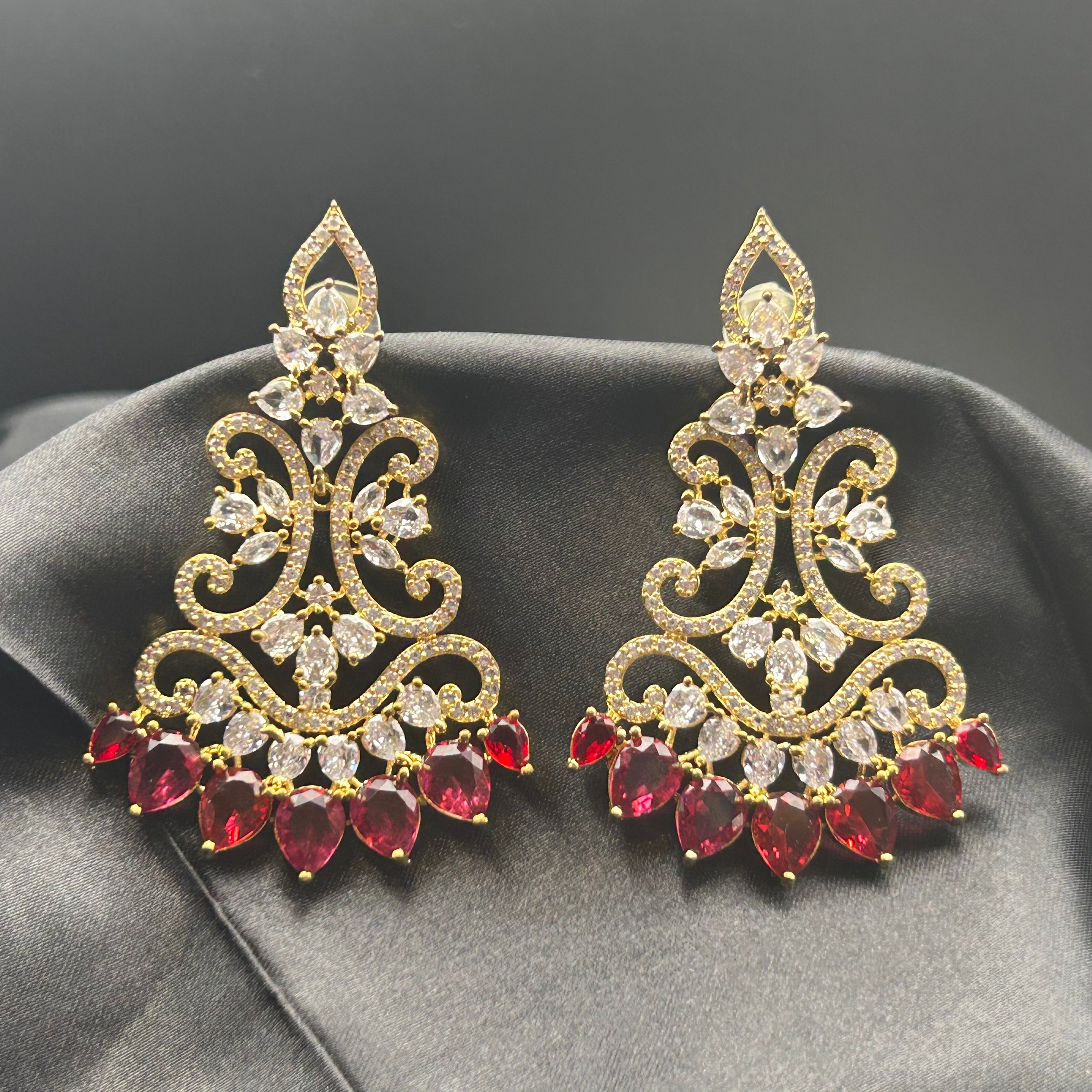 gold plated with American diamonds and red gemstones on a black silk cloth
